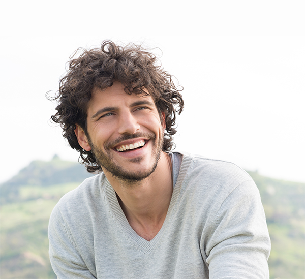 man smiling in grey sweater